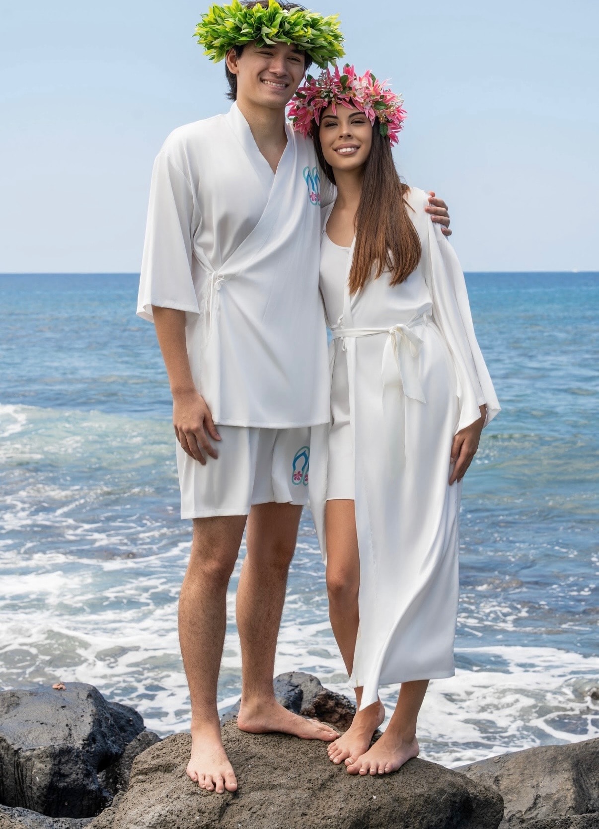 Beach couple in white resort kimonos with flower lei